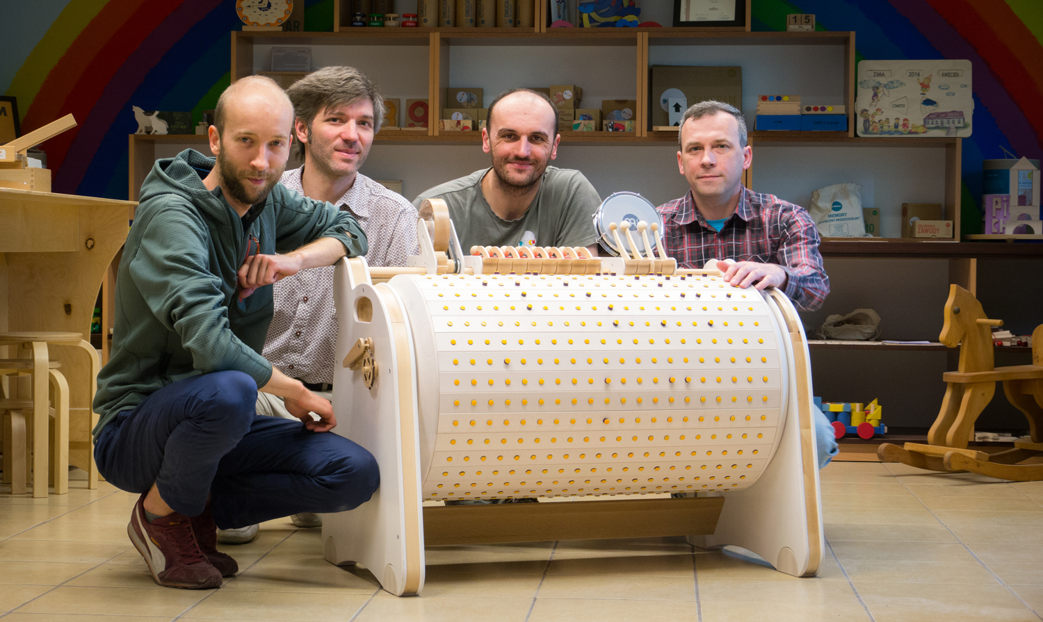 Czterech uśmiechniętych mężczyzn pewnie wynalazców kuca przy Musiconie