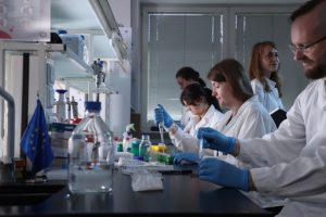 Zdjęcie przedstawia grupę naukowców przy pracy w laboratorium